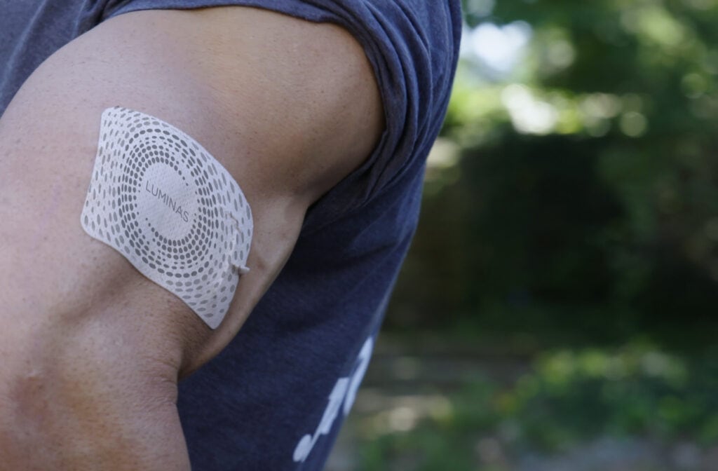 A man taking benefit of Luminas patch by using on his arm