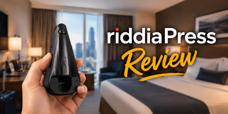 A person holding the black riddiaPress cordless travel iron in a hotel room.